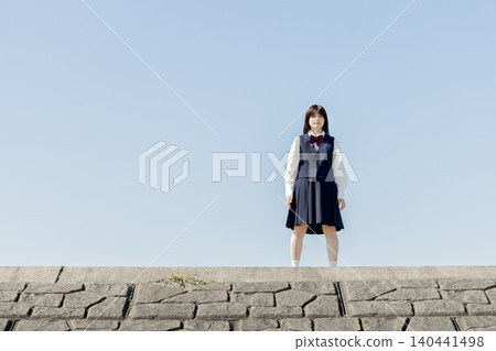 A high school girl standing under a blue sky A high school girl standing under a blue sky 140441498