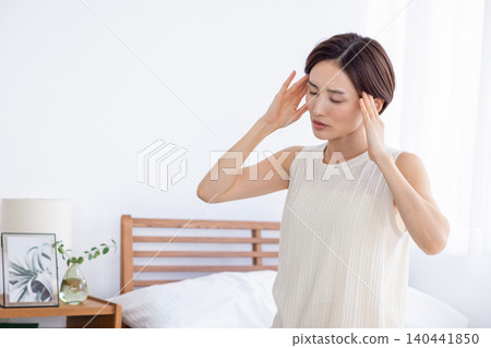 一位女士早上感覺身體不適,頭痛。 一位女士早上感覺身體不適,頭痛。 140441850
