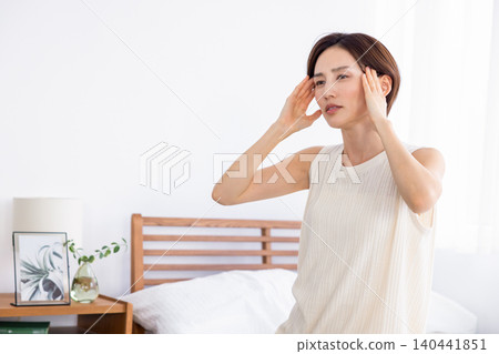 一位女士早上感覺身體不適,頭痛。 一位女士早上感覺身體不適,頭痛。 140441851