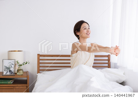 A woman wakes up refreshed after a deep sleep in the morning 140441967