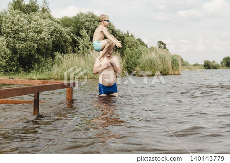 dynamic, relaxed shot boy jumping into natural lake. child is captured mid flight, creating sense excitement. image perfect family vacations, water safety, promoting active lifestyle among children dynamic, relaxed shot boy jumping into natural lake. child is captured mid flight, creating sense excitement. image perfect family vacations, water safety, promoting active lifestyle among children 140443779