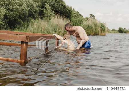 dynamic, relaxed shot boy jumping into natural lake. child is captured mid flight, creating sense excitement. image perfect family vacations, water safety, promoting active lifestyle among children dynamic, relaxed shot boy jumping into natural lake. child is captured mid flight, creating sense excitement. image perfect family vacations, water safety, promoting active lifestyle among children 140443781