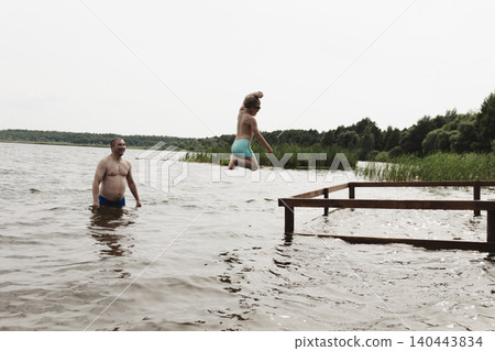 dynamic, relaxed shot boy jumping into natural lake. child is captured mid flight, creating sense excitement. image perfect family vacations, water safety, promoting active lifestyle among children dynamic, relaxed shot boy jumping into natural lake. child is captured mid flight, creating sense excitement. image perfect family vacations, water safety, promoting active lifestyle among children 140443834