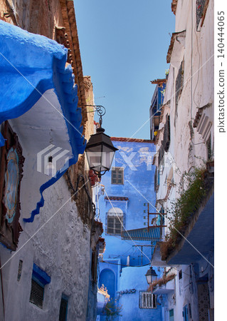 A narrow pedestrian street displays its bright blue painted walls in the medina of Chefchaouen, Morocco A narrow pedestrian street displays its bright blue painted walls in the medina of Chefchaouen, Morocco 140444065