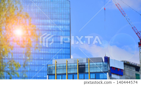 Crane on the construction site in a site surrounded by the high buildings. Office building under construction in the vicinity of high apartment buildings and office building. Crane on the construction site in a site surrounded by the high buildings. Office building under construction in the vicinity of high apartment buildings and office building. 140444574