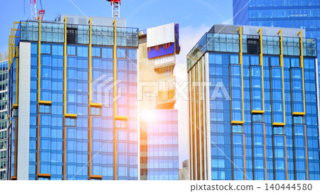 Crane on the construction site in a site surrounded by the high buildings. Office building under construction in the vicinity of high apartment buildings and office building. Crane on the construction site in a site surrounded by the high buildings. Office building under construction in the vicinity of high apartment buildings and office building. 140444580