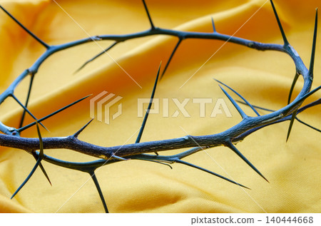 Golden Light Crown of Thorns on Yellow Silk Fabric for Easter Concept Golden Light Crown of Thorns on Yellow Silk Fabric for Easter Concept 140444668