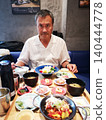 一名男子在餐廳吃午飯，餐廳正在比較不同種類的米。 140444778