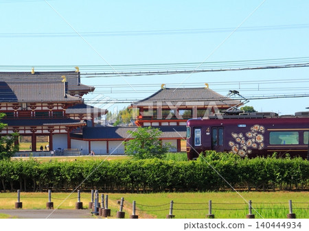 近鐵觀光特快列車「青吉」沿著世界遺產平城宮遺址內的重建遺址運行。 140444934