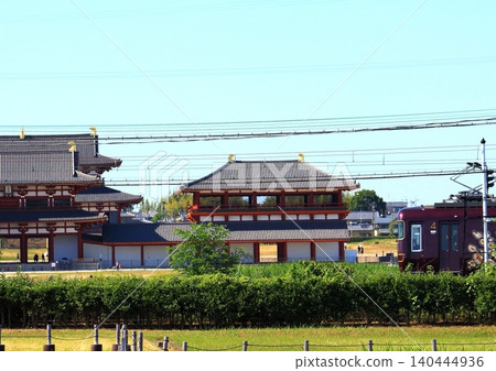 Kintetsu's sightseeing limited express train "Aoniyoshi" runs alongside the reconstructed ruins within the Heijo Palace Site, a World Heritage Site. 140444936