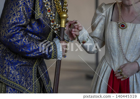 Royal Costume Hand With Jeweled Rings And Cane In Blue Gold Brocade Attire At Event 140445319