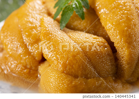 A luxurious seafood dish featuring fresh sea urchin from Hokkaido piled high in a glass bowl. A luxurious seafood dish featuring fresh sea urchin from Hokkaido piled high in a glass bowl. 140445341