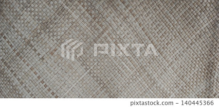 A traditional woven palm leaf mat featuring a delicate geometric diamond pattern. A traditional woven palm leaf mat featuring a delicate geometric diamond pattern. 140445366