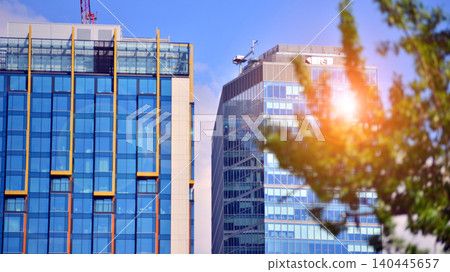 Sustainable glass office building with trees for reducing carbon dioxide. Eco-friendly building in modern city. Office with green environment. Corporate building reduce CO2. Sustainable glass office building with trees for reducing carbon dioxide. Eco-friendly building in modern city. Office with green environment. Corporate building reduce CO2. 140445657