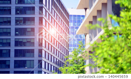 Sustainable glass office building with trees for reducing carbon dioxide. Eco-friendly building in modern city. Office with green environment. Corporate building reduce CO2. Sustainable glass office building with trees for reducing carbon dioxide. Eco-friendly building in modern city. Office with green environment. Corporate building reduce CO2. 140445659