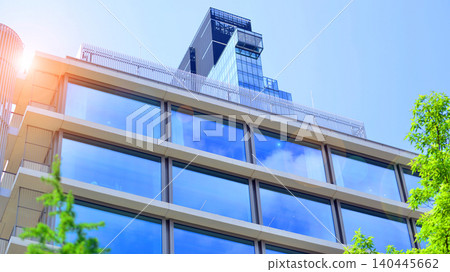 Sustainable glass office building with trees for reducing carbon dioxide. Eco-friendly building in modern city. Office with green environment. Corporate building reduce CO2. 140445662