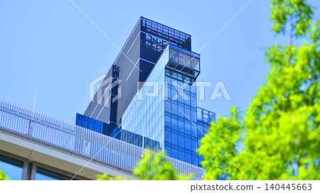 Sustainable glass office building with trees for reducing carbon dioxide. Eco-friendly building in modern city. Office with green environment. Corporate building reduce CO2. 140445663