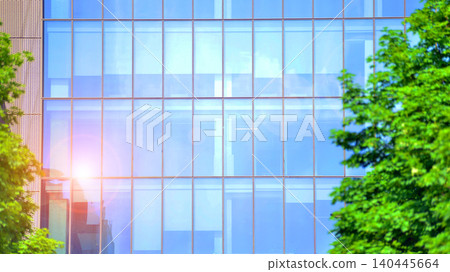 Sustainable glass office building with trees for reducing carbon dioxide. Eco-friendly building in modern city. Office with green environment. Corporate building reduce CO2. 140445664