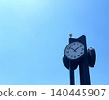 An outdoor clock towering against the blue sky (image of business and time) 140445907