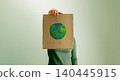 arth Day expression with person holding cardboard sign and hand painted globe, environmental awareness 140445915