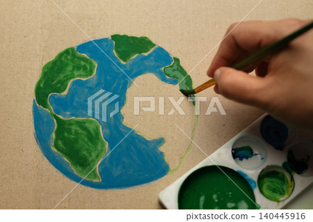 Earth Day painting activist concept with hand painting globe on cardboard, eco creativity Earth Day painting activist concept with hand painting globe on cardboard, eco creativity 140445916
