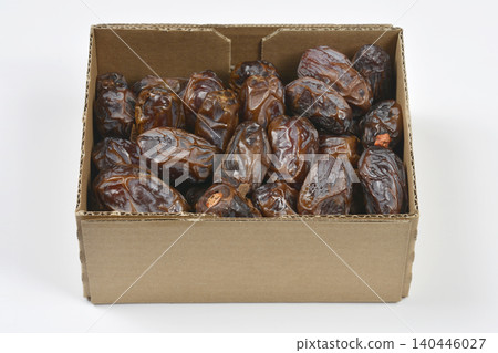 Side angle shot of Medjool dates packed in a cardboard box 140446027