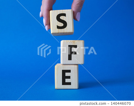 SFE - Sales Force Effectiveness. Wooden cubes with word SFE. Businessman hand. Beautiful blue background. Business and Sales Force Effectiveness concept. Copy space. SFE - Sales Force Effectiveness. Wooden cubes with word SFE. Businessman hand. Beautiful blue background. Business and Sales Force Effectiveness concept. Copy space. 140446070