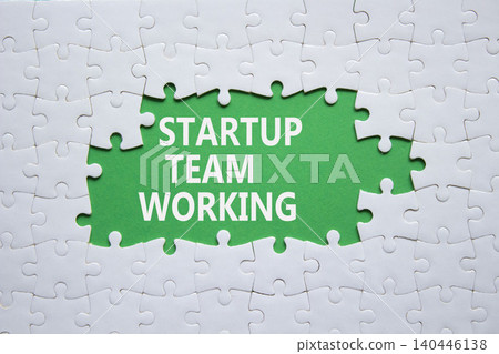 Startup Team Working symbol. White puzzle with words Startup Team Working. Beautiful green background. Business concept. Copy space. Startup Team Working symbol. White puzzle with words Startup Team Working. Beautiful green background. Business concept. Copy space. 140446138