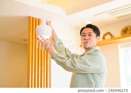 Japanese man installing lights Japanese man installing lights 140446273