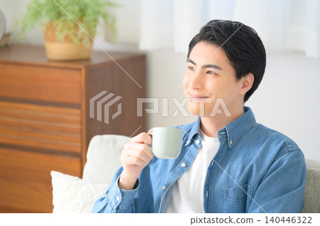 A Japanese man relaxing while drinking coffee. 140446322