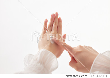 A woman in her 20s applying cream to the back of her hand. A woman in her 20s applying cream to the back of her hand. 140447091