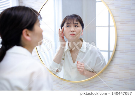 照鏡子時，會擔心自己髮際線後移的老年女性 140447097