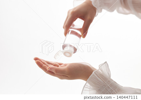一位二十多歲女性的手，她正在拿起潤膚露。 140447111