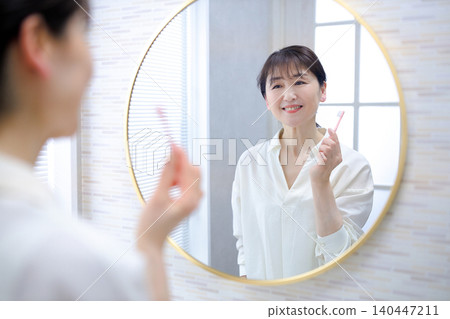 A senior woman brushing her teeth A senior woman brushing her teeth 140447211