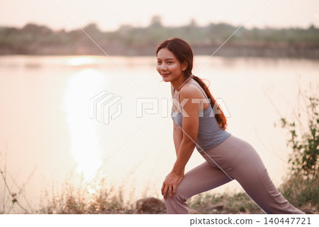 Woman holding a low lunge stretch beside a lake at sunset, highlighting outdoor yoga practice, hip mobility, flexibility, mindful breathing, wellness routine, strength, balance, Woman holding a low lunge stretch beside a lake at sunset, highlighting outdoor yoga practice, hip mobility, flexibility, mindful breathing, wellness routine, strength, balance, 140447721
