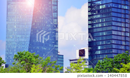 Modern office building with glass facade on a clear sky background. Transparent glass wall of office building. 140447858