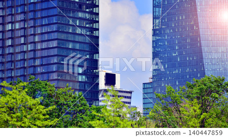 Modern office building with glass facade on a clear sky background. Transparent glass wall of office building. 140447859