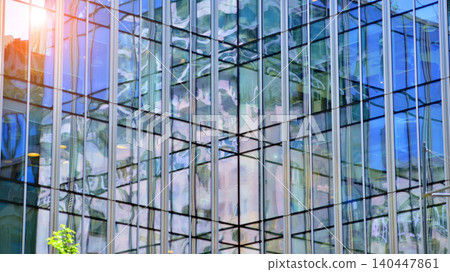 Modern office building with glass facade on a clear sky background. Transparent glass wall of office building. 140447861