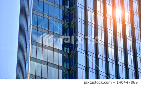 Modern office building with glass facade on a clear sky background. Transparent glass wall of office building. 140447869