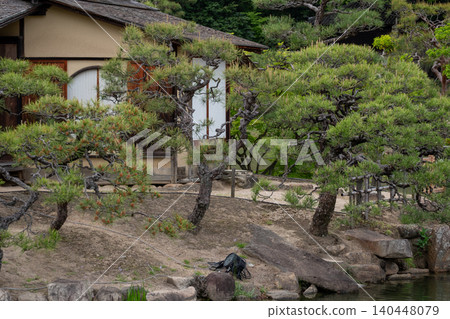 A traditional tea house and Japanese garden landscape standing by the pond. A traditional tea house and Japanese garden landscape standing by the pond. 140448079
