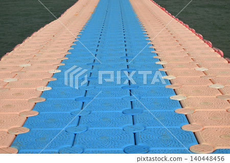 Colorful floating platforms made of plastic stand out in the sea off Ban Amphoe beach, providing a place for tourists to walk and relax, and sometimes even serving as piers. Colorful floating platforms made of plastic stand out in the sea off Ban Amphoe beach, providing a place for tourists to walk and relax, and sometimes even serving as piers. 140448456
