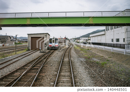 當地鐵路列車和列車車庫停放在亮綠色高架橋下的景象。 當地鐵路列車和列車車庫停放在亮綠色高架橋下的景象。 140448501