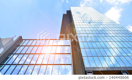 View of modern office building with many windows against clear sky. Glass facade wall. View of modern office building with many windows against clear sky. Glass facade wall. 140448606