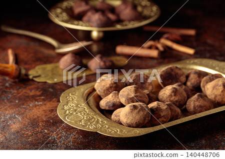 Chocolate truffles in old brass dish. 140448706