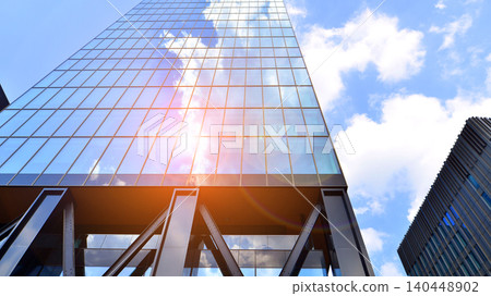 Steel and glass. The subject of modern architecture or construction industry. Modern office building facade with tall steel construction elements and full height windows between. Steel and glass. The subject of modern architecture or construction industry. Modern office building facade with tall steel construction elements and full height windows between. 140448902