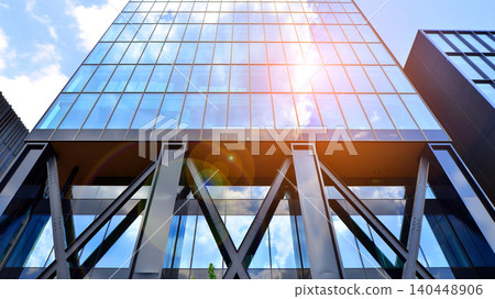 Steel and glass. The subject of modern architecture or construction industry. Modern office building facade with tall steel construction elements and full height windows between. Steel and glass. The subject of modern architecture or construction industry. Modern office building facade with tall steel construction elements and full height windows between. 140448906