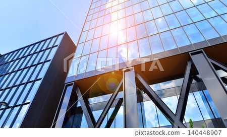 Steel and glass. The subject of modern architecture or construction industry. Modern office building facade with tall steel construction elements and full height windows between. Steel and glass. The subject of modern architecture or construction industry. Modern office building facade with tall steel construction elements and full height windows between. 140448907