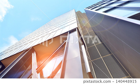 Steel and glass. The subject of modern architecture or construction industry. Modern office building facade with tall steel construction elements and full height windows between. Steel and glass. The subject of modern architecture or construction industry. Modern office building facade with tall steel construction elements and full height windows between. 140448915