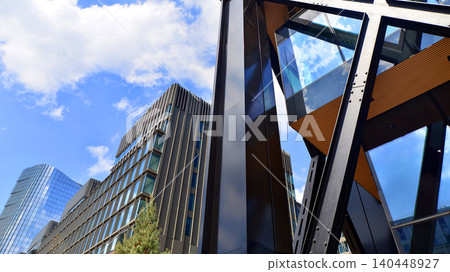 Steel and glass. The subject of modern architecture or construction industry. Modern office building facade with tall steel construction elements and full height windows between. Steel and glass. The subject of modern architecture or construction industry. Modern office building facade with tall steel construction elements and full height windows between. 140448927