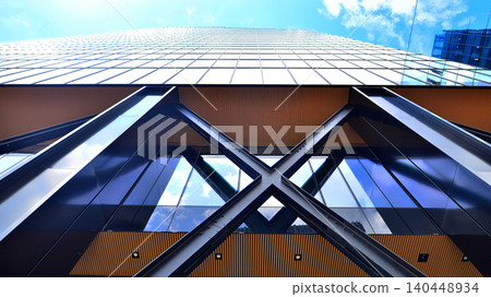 Steel and glass. The subject of modern architecture or construction industry. Modern office building facade with tall steel construction elements and full height windows between. Steel and glass. The subject of modern architecture or construction industry. Modern office building facade with tall steel construction elements and full height windows between. 140448934